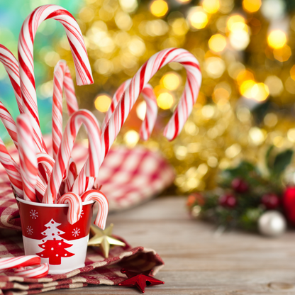 Candy Canes in a red and white christmas tree paper cup with a gold christmas tree in the background